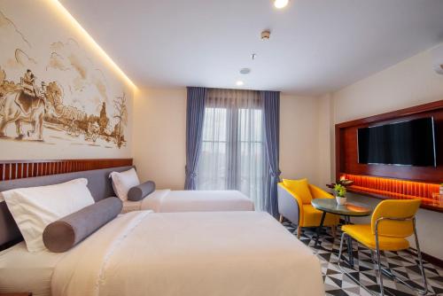 a hotel room with two beds and a flat screen tv at The Twizt - Lifestyle Hostel & Hotel in Siem Reap