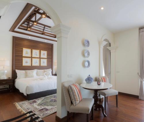 sypialnia z łóżkiem, stołem i krzesłami w obiekcie Content Villa Chiangmai w mieście Chiang Mai