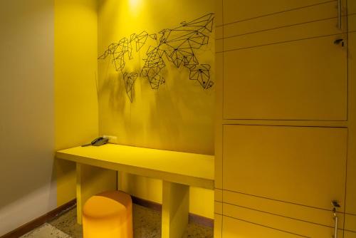 a yellow bathroom with a desk and a cabinet at The Twizt - Lifestyle Hostel & Hotel in Siem Reap