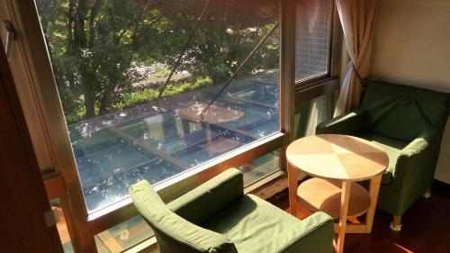 a room with a window and two chairs and a table at Rainbow Bridge B&B in Sanzhi