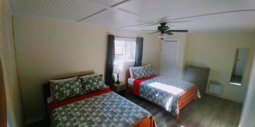 a bedroom with two beds and a ceiling fan at Millstream Cottages in Brackley Beach