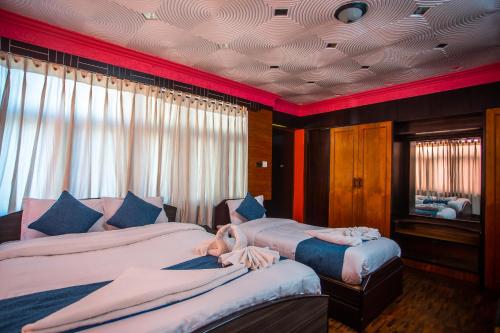 a bedroom with two beds with a person laying on them at Hotel Green Horizon in Kathmandu
