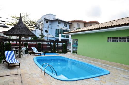 una piscina con 2 sillas y una mesa en Pousada Mar Do Leste, en Florianópolis