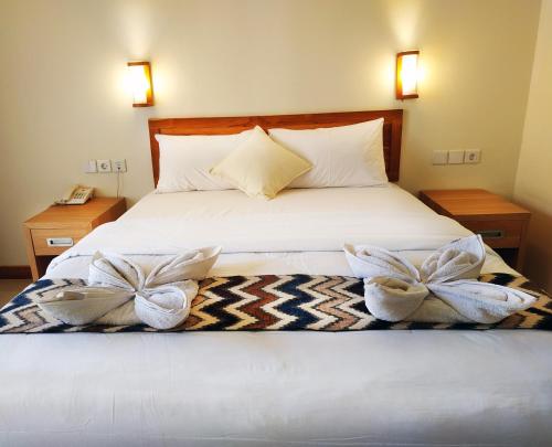 a bedroom with a bed with bows on it at Komodo Lodge in Labuan Bajo