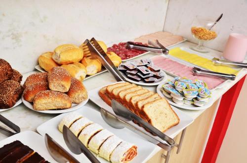 a table filled with different types of bread and pastries at Pousada Mar Do Leste in Florianópolis