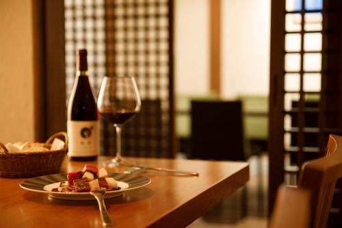 a plate of food and a glass of wine on a table at Satoyama No Auberge Maki No Oto in Nanto
