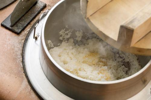 a pot full of rice on a counter with a mortar at Satoyama No Auberge Maki No Oto in Nanto