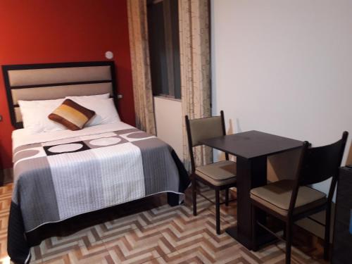 a bedroom with a bed and a table and chairs at Gavina Inn Hotel in Tacna