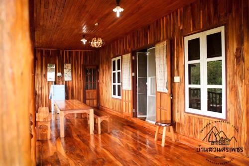 a room with wooden walls and floors and windows at บ้านสวนศรเพชร in Phetchabun