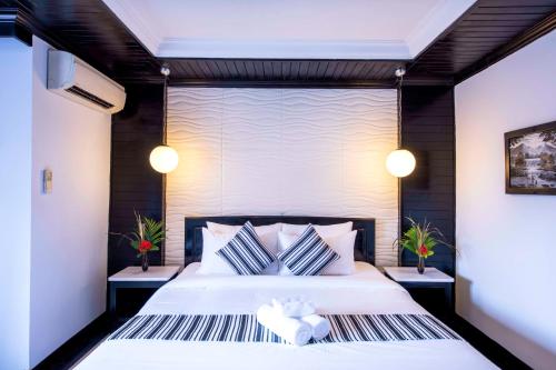 a bedroom with a large bed with two pillows at The Sanctuary Residence in Siem Reap