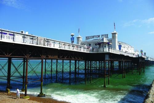 a pier with people standing on the beach near the water at Britannia Study Hotel in Brighton & Hove