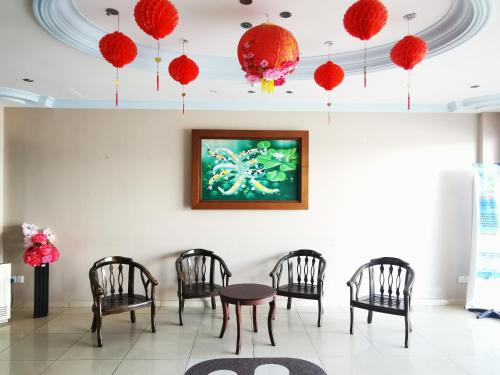 瓜埠的住宿－桑德蘭汽車旅館，一间设有椅子和一张桌子的房间,墙上有一幅画