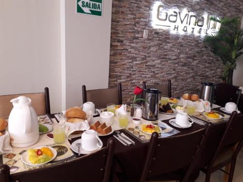 a dining table with breakfast foods on it at Gavina Inn Hotel in Tacna