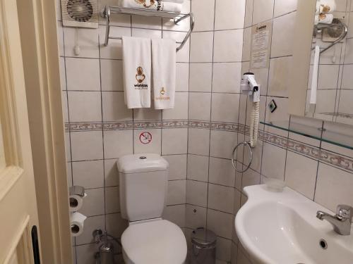 a small bathroom with a toilet and a sink at Minyon Hotel in Antalya