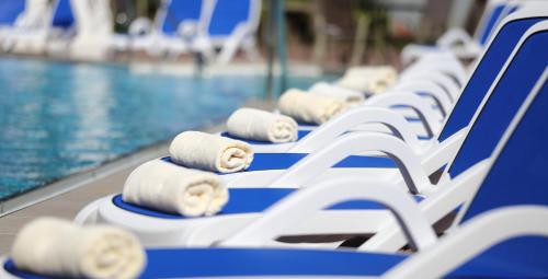 a row of blue and white chairs next to a swimming pool at Hotel des Nordens Flensburg Wellness & Spa in Flensburg
