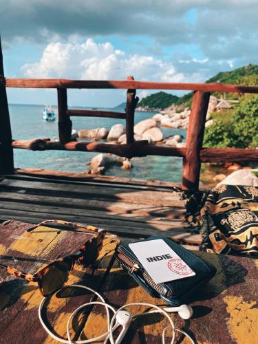 a table with glasses and a book on top of a boat at Indie Hostel - Koh Tao in Koh Tao