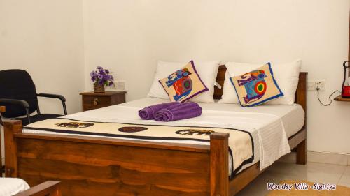 a bed with white sheets and pillows in a room at Woodsy Villa in Sigiriya
