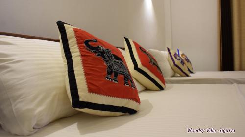 a group of pillows on a bed in a room at Woodsy Villa in Sigiriya