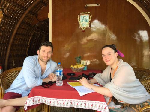 a man and a woman sitting at a table at Thara's Houseboat in Alleppey