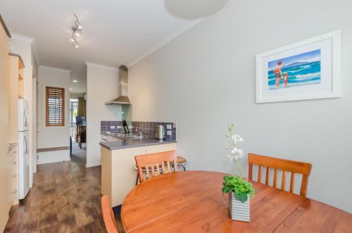 a dining room and kitchen with a table and chairs at Raumati Sands Resort in Paraparaumu Beach