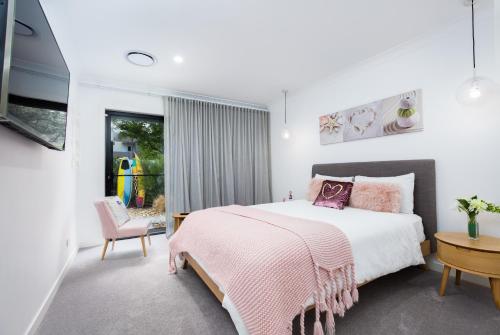 a bedroom with a bed with a pink blanket at Lamour Holiday Beach House in Gold Coast