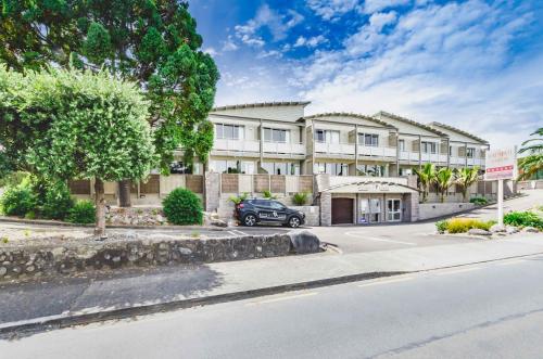 a building with a car parked in front of it at Raumati Sands Resort in Paraparaumu Beach