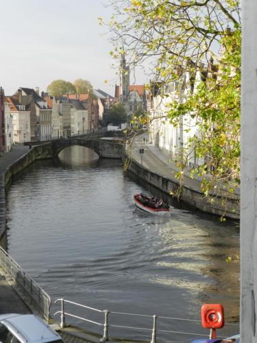 a small boat in a river in a city at Apartment Het Blekershuys in Bruges
