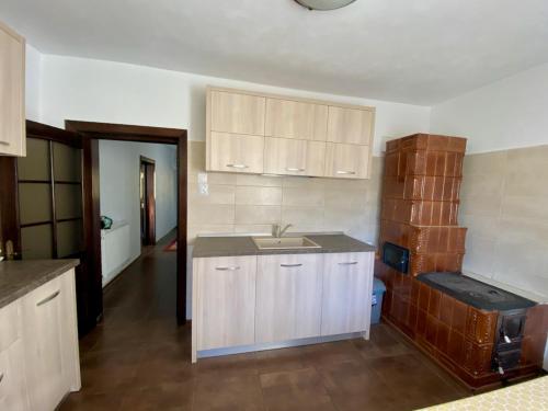 a kitchen with white cabinets and a sink at Cabana Caprioara - Piatra Craiului in Dâmbovicioara