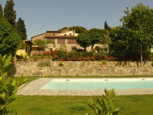 a swimming pool in a yard with a house in the background at Agriturismo Conca Verde in Scandicci