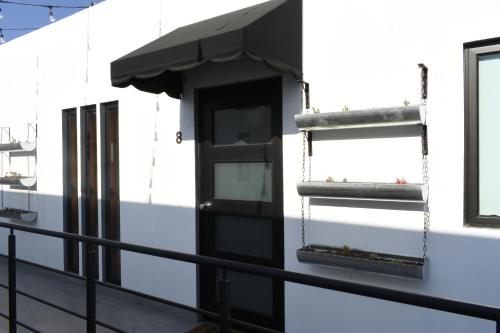 a balcony with a black door on a white building at TJ Border Suites by Hosted by Me in Tijuana