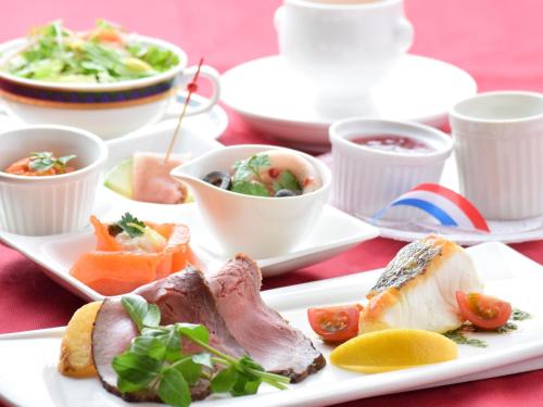 a white plate with food on a red table at Grand Park Hotel Okubiwako Makino in Takashima