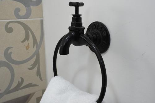 a black lamp hanging on a wall with a towel at TJ Border Suites by Hosted by Me in Tijuana