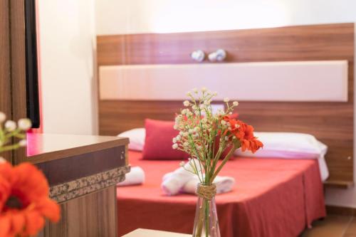 
a room with a bed, a table and a vase of flowers at Hostal Rural La Fonda Del Rocio in El Rocío
