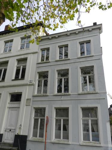 a white building with many windows on a street at Apartment Het Blekershuys in Bruges