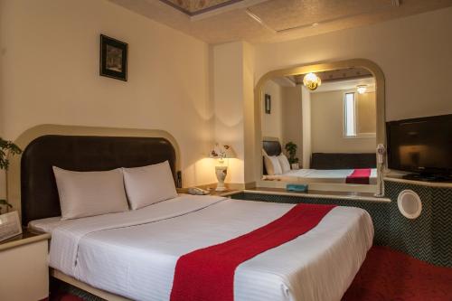 Pokój hotelowy z dużym łóżkiem i lustrem w obiekcie Good Hotel w mieście Fengyuan