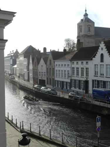 a boat in a river in a city with buildings at Apartment Het Blekershuys in Bruges