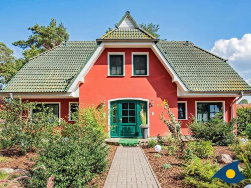 a red house with a green door at Fraeulein Loddin Whg_ Hugo in Kölpinsee