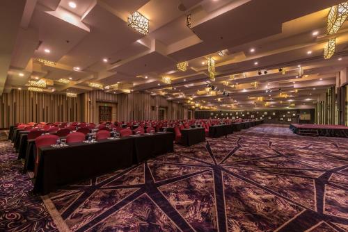 a large room with red chairs and tables in it at Holiday Inn Cikarang Jababeka by IHG in Cikarang