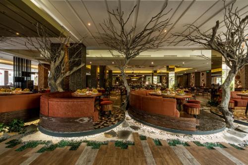 a restaurant with trees in the middle of a lobby at Holiday Inn Cikarang Jababeka by IHG in Cikarang