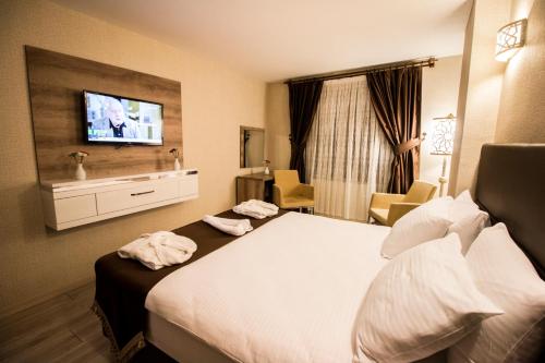 a hotel room with a bed and a tv at Business Han Hotel in Nevsehir