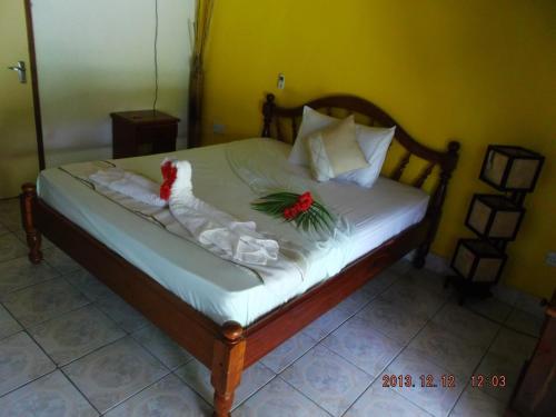 a bed with two roses and a chicken on it at Belle Amie Self Catering in La Digue