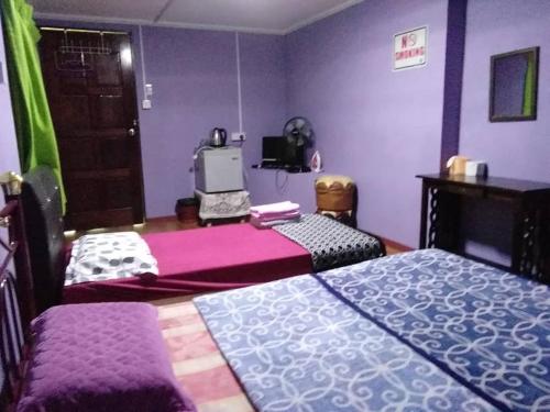 a purple room with two beds and a tv at Ren-Hana Kundasang in Kundasang