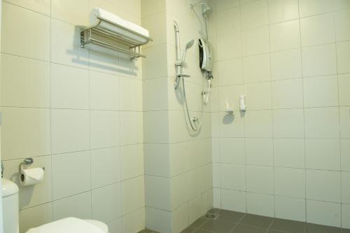 bagno bianco con doccia e servizi igienici di Ezzyhome@Medini a Nusajaya