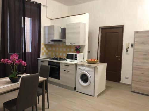 a kitchen with a washing machine and a microwave at Civico 10 in Sassari
