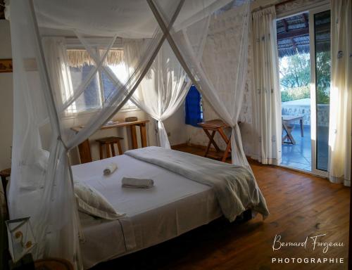 a bedroom with a bed with a mosquito net at Salary Bay in Tsifota