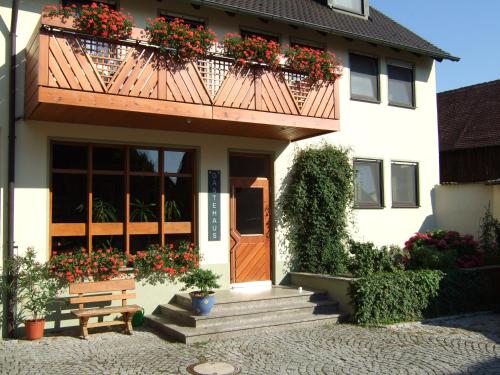 a house with a balcony with flowers on it at Brauerei_Gasthof Pfister in Eggolsheim