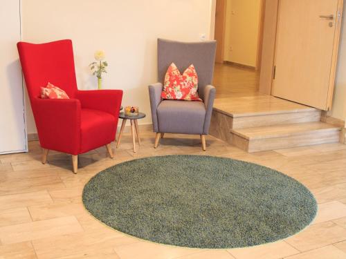 a living room with two chairs and a rug at Brauerei_Gasthof Pfister in Eggolsheim