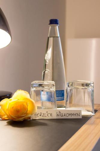 a bottle of water and a flower on a table at Brauerei_Gasthof Pfister in Eggolsheim