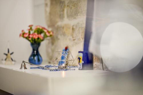 un comptoir avec un vase de fleurs et une bougie dans l'établissement MarMar, à Split