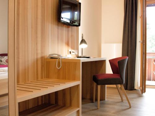 a room with a desk and a red chair at Brauerei_Gasthof Pfister in Eggolsheim